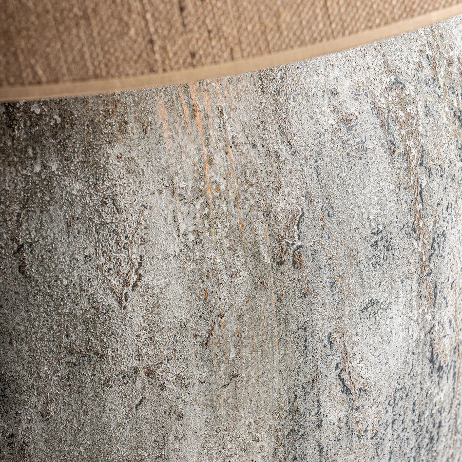 Textura rugosa del cemento gris con vetas ocres de la base de la lámpara Yrsa