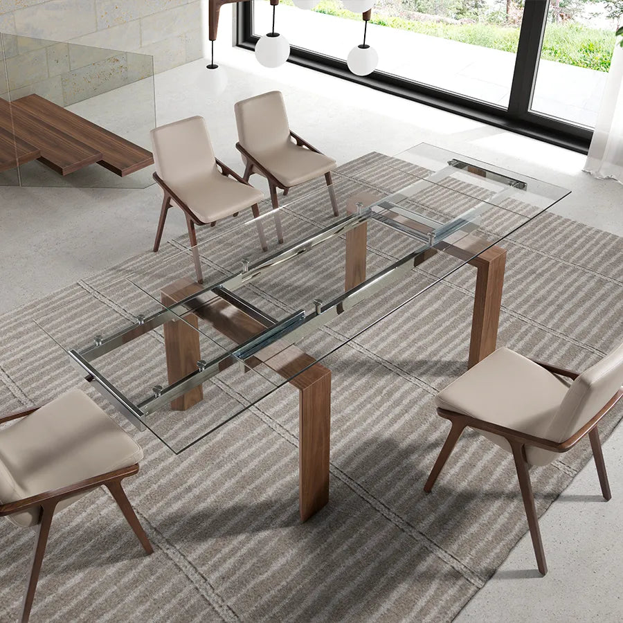 Mesa de Comedor Extensible 1007 vista cenital en un comedor, extendida y rodeada de cuatro butacas de nogal