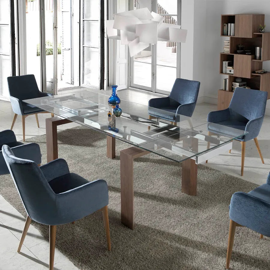 Mesa de Comedor Extensible 1007 extendida en un comedor luminoso, rodeada de butacas tapizadas en azul