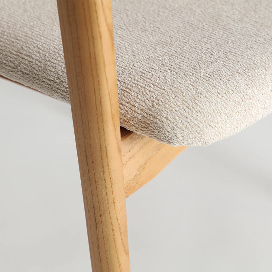 Detalle del asiento tapizado en crema y la madera de olmo de la Silla Eriswil