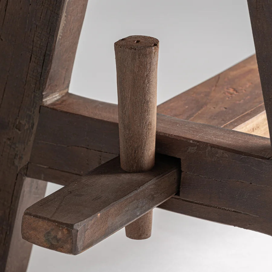 Clavija de madera vista que une la pata con el travesaño del Taburete Tabou